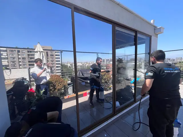 Instaladores de SolarGlass aplicando lámina en una terraza